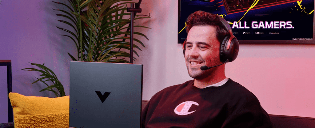 Homem usando laptop HP Victus com fones de ouvido Hyperx
